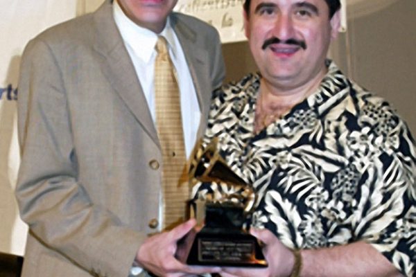 Flautist Dave Valentin displays his grammy award for Best Latin Jazz Album- 2002, Caribbean Jazz Project, "The Gathering" backstage after Homenaje a Mongo Santamaria Concert, June 16, 2003, Seuffert Bandshell, Woodhaven Queens, New York (photo credit Jerry Lacay)
